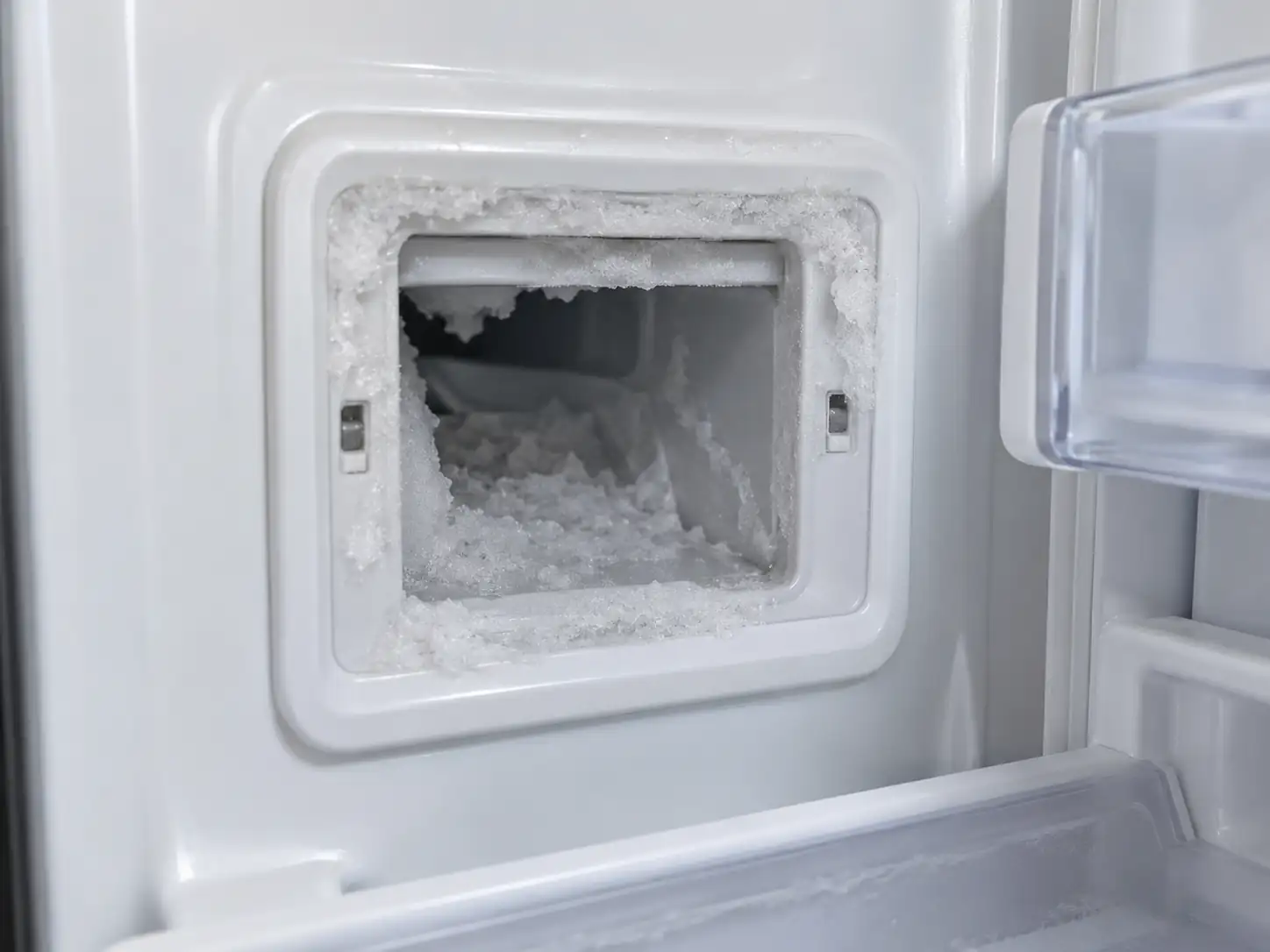 Frozen refrigerator ice dispenser chute blocked by frost and ice